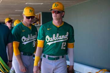 Oakland Athletics' Jack Winkler (12) and Will Simpson, left, walk through the dugout prior ...