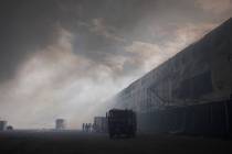 Smoke rises above warehouse stores after a Russian air attack in Kyiv, Ukraine, Thursday, Aug. ...