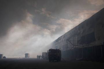 Smoke rises above warehouse stores after a Russian air attack in Kyiv, Ukraine, Thursday, Aug. ...