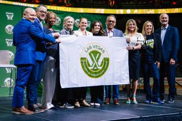 A group poses with a Las Vegas PWHL flag during an introductory press conference for a Las Vega ...