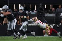 Raiders quarterback Fernando Mendoza (15) tries to avoid getting sacked by San Francisco 49ers ...