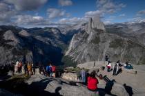 People gather at Glacier Point to look at Half Dome in Yosemite National Park on May 17, 2026, ...