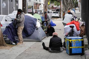 Homeless people gather with their belongings and tents in the Mission District, Tuesday, Sept. ...