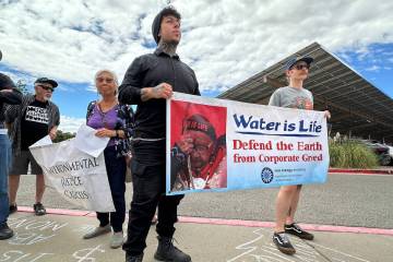 Protesters hold signs in opposition of the Project Jupiter data center during a demonstration o ...
