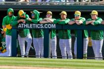 Athletics players and staff watch a spring training baseball game against the Cleveland Guardia ...