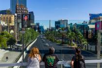 Pedestrians watch from above as emergency vehicles make their way down the Strip following a he ...
