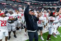 New Mexico Lobos head coach Jason Eck and players celebrate their win over UNLV 40-35 with the ...