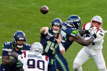 Seattle Seahawks quarterback Sam Darnold (14) throws a pass under pressure from New England Pat ...