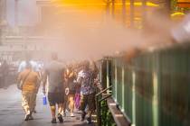 People cool off by misters while walking along the Las Vegas Strip near Paris Las Vegas in JUly ...