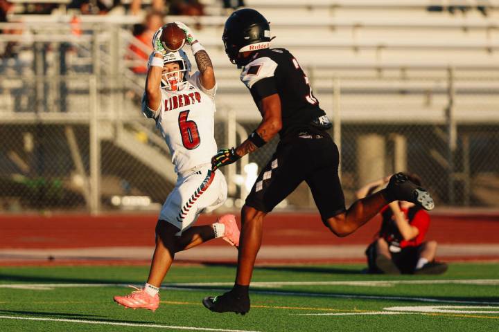 Liberty wide receiver Kainalu Hosaka (6) catches the ball for a touchdown against Desert Oasis ...