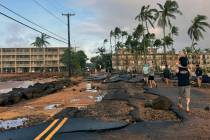People walk past damage caused by Hurricane Lowell on Tuesday, Sept. 8, 2026 in Poipu on Kaua?' ...