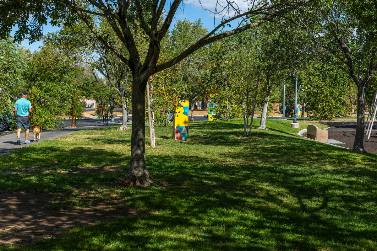 A man walks his dog along a path in Bruce Trent Park in Las Vegas on September 17, 2026, a neighborhood park with mixed grass and desert landscaping