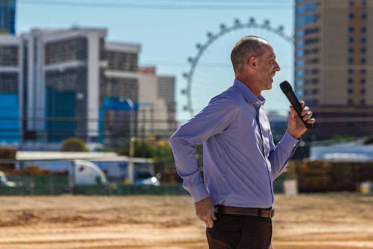 A speaker addresses the crowd at the Jewel groundbreaking in Las Vegas Chinatown with the High Roller observation wheel and Strip towers in the background