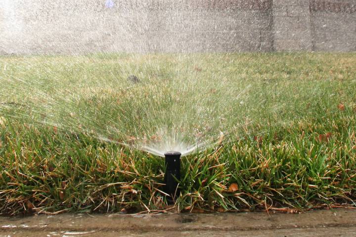 A sprinkler is on to water grass at Green Valley Parkway on Tuesday, March 5, 2019, in Henderso ...