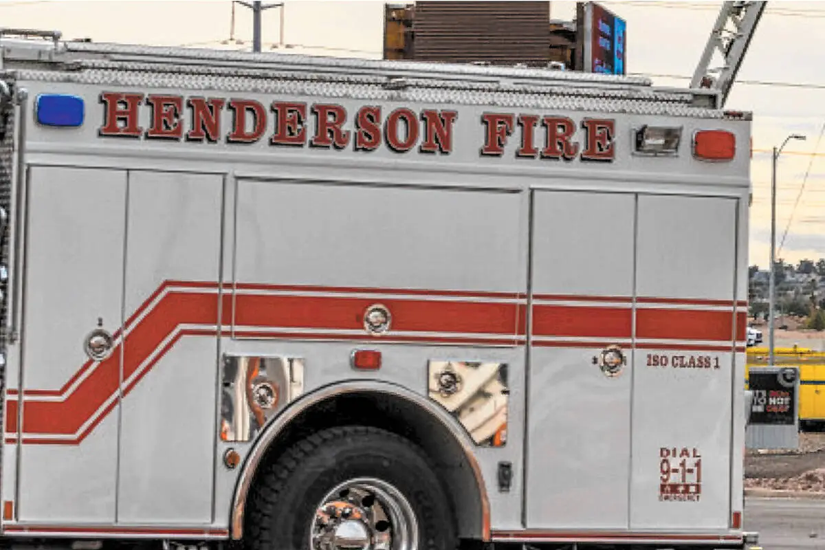 Henderson Fire Department technical rescue crew at a stalled car in standing water near Moonwalk Terrace and East Paradise Hills Drive in Henderson