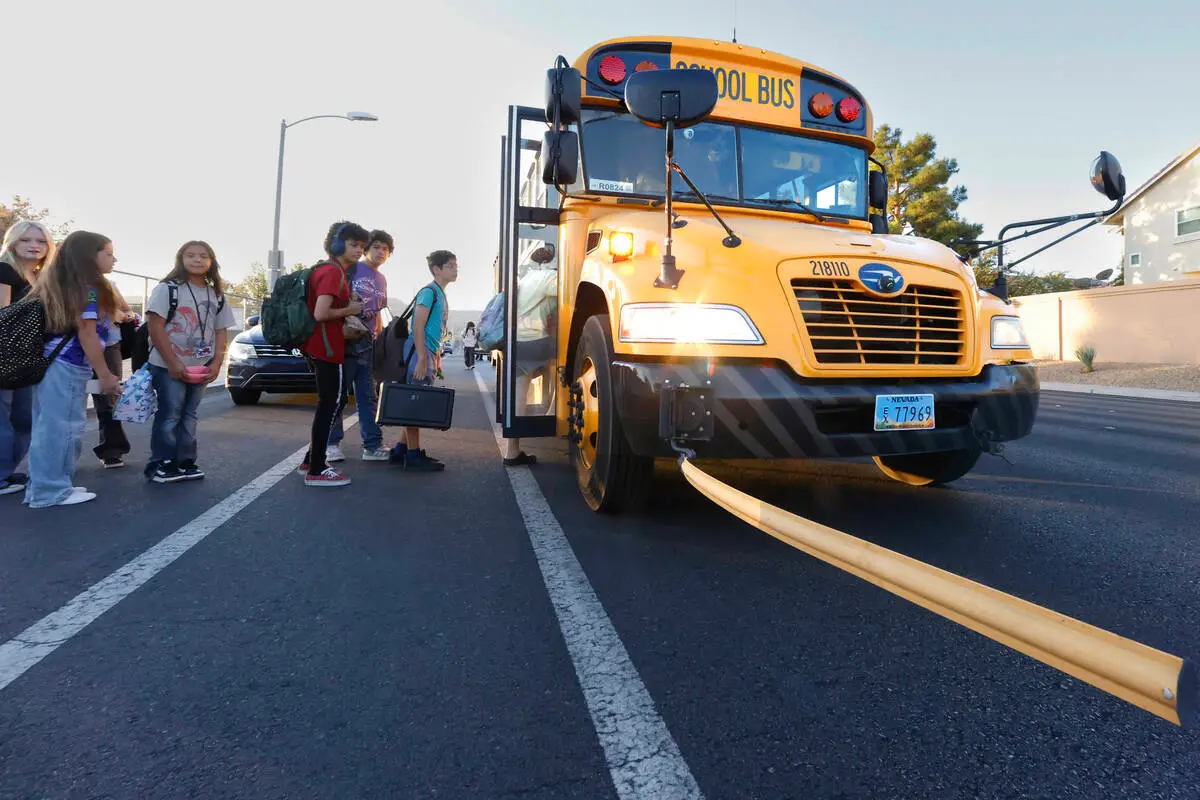Students board a Clark County School District bus with its stop arm extended near Greenspun Junior High School in Henderson