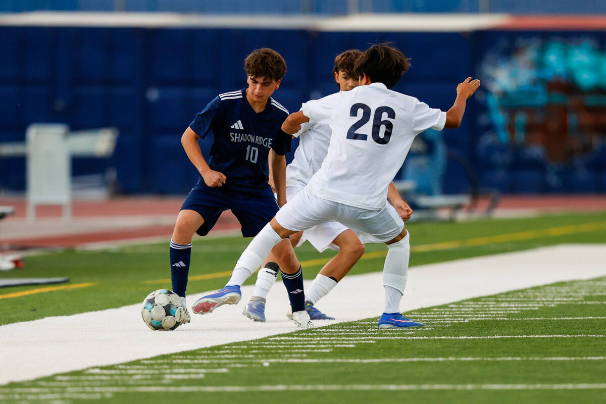 Shadow Ridge sophomore Becket Jensen (10) looks to dribble past a Centennial defender (name not ...
