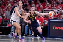 Indiana Fever guard Caitlin Clark (22) drives past Las Vegas Aces forward Stephanie Talbot, lef ...