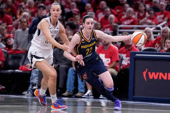 Indiana Fever guard Caitlin Clark (22) drives past Las Vegas Aces forward Stephanie Talbot, lef ...