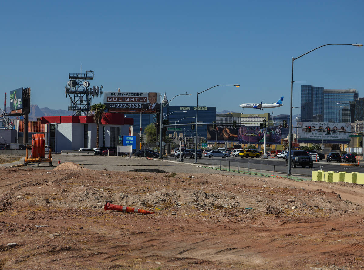 A jet lands at Harry Reid International Airport behind the vacant UNLV land on Tropicana Avenue, showing how close the lot sits to the runways