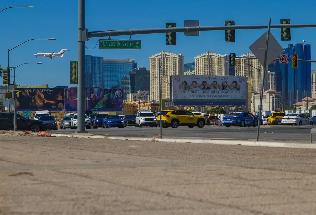 Las Vegas Strip towers and a plane on approach seen from the corner of Tropicana Avenue and University Center Drive near the UNLV land